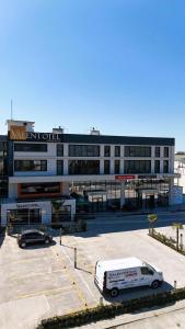 una furgoneta blanca estacionada en un estacionamiento frente a un edificio en VALENT OTEL BUSINESS, en Balıkesir