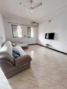 a living room with a couch and a flat screen tv at Tropicana Villa Nungwi in Kinyasini