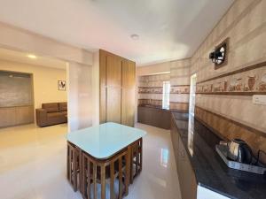 a kitchen with a table in the middle of a room at The Pearl Residency 2BHK 3BHK Apartments in Ooty