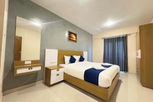 a bedroom with a large bed and a mirror at The Pearl Residency 2BHK 3BHK Apartments in Ooty