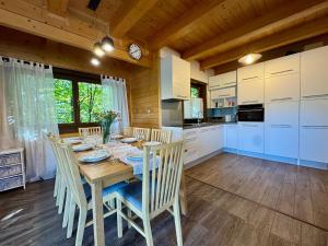 Una cocina y un comedor con mesa y sillas. en Willa Sportowa - boisko, sauna, jacuzzi, en Porąbka