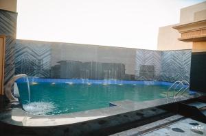 a swimming pool with a fountain in a building at Parin Azure Hotels & Resorts in Amritsar