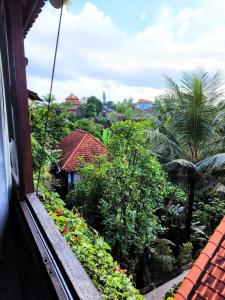 a view of a garden from a window of a house at Huge Amazing Campuhan Ridge Walk view room in Ubud