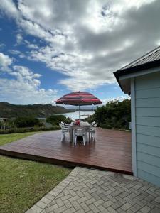 een tafel met een paraplu op een houten terras bij Traka Cottages in Sedgefield