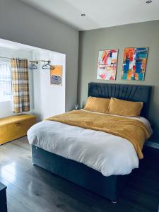 um quarto com uma cama grande com cabeceira azul em Burton Urban Apartment em Burton upon Trent