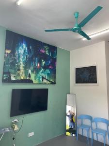 Una sala de estar con un televisor de pantalla plana en una pared. en Homestay Kg Razali, en Kuantan
