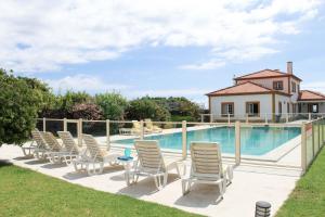a row of chairs sitting next to a swimming pool at BayHouse in Porto Martins