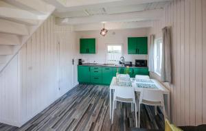 LalikiにあるAmazing Home In Lalikiのキッチン(緑のキャビネット、白いテーブルと椅子付)