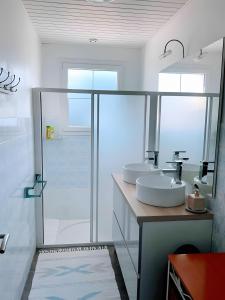 une salle de bain avec deux lavabos et une douche dans l'établissement Cottage Chaleureux Proche Ocean, à Salles-sur-Mer