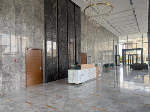 a lobby with a person sitting at a desk in a building at AEON Towers Lucky Cloud #701 in Banī Ghālib +50 photos