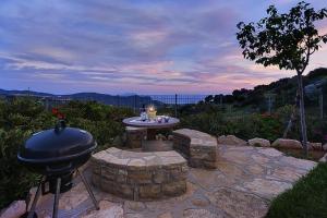 a grill and a table on a stone patio at Villa, Triopetra in Akoumia
