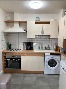 a kitchen with a sink and a washing machine at Résidence le 46 in Concarneau