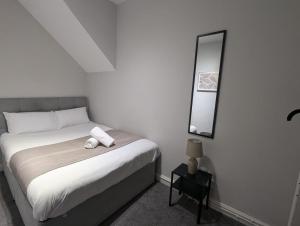 a white bedroom with a bed and a mirror at Town Hall Property in South Shields