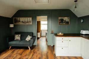 a living room with green walls and a couch at Louisa's Loft in Killyhevlin