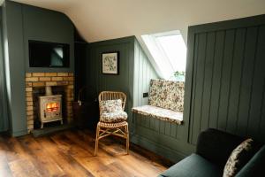 a living room with a chair and a fireplace at Louisa's Loft in Killyhevlin