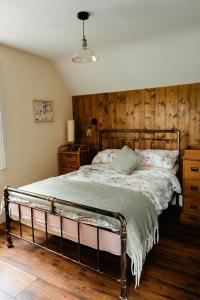 a bedroom with a bed and a wooden wall at Louisa's Loft in Enniskillen