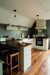a kitchen with white cabinets and a black counter top at Louisa's Loft in Enniskillen