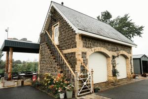 a small brick building with a garage and a door at Louisa's Loft in Killyhevlin