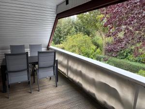 Un balcón con mesa y sillas y una gran ventana. en Balkon Hüs, en Alkersum