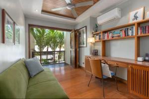 sala de estar con sofá verde y escritorio en Far Pavilions Villa A, Luxe 2-BR Hillside Escape, en Port Douglas 6 fotos más