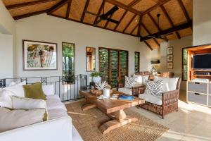 una sala de estar con un sofá y una mesa en Far Pavilions Villa A, Luxe 2-BR Hillside Escape, en Port Douglas