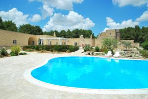 サンニコーラにあるMasseria Relais Santa Teresaの建物のある庭のスイミングプール