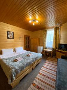 a bedroom with a large bed in a wooden room at Під каштаном in Vorokhta