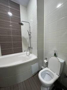 a bathroom with a toilet and a tub and a sink at Maskan Hotel in Aktepa-Chigatay