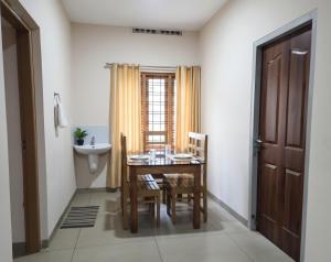a dining room with a table and chairs and a sink at Anand homestay in Kattappana