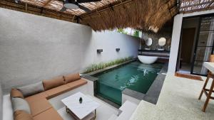 日惹JBS Villa的房子中间有一个游泳池，配有沙发和浴缸