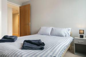 ベルファストにあるModern City Centre Apartmentの青いタオルが敷かれたベッドのある寝室