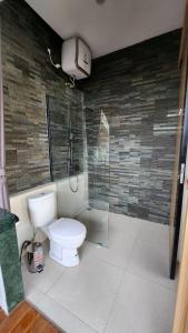 a bathroom with a toilet and a shower stall at JBS Villa in Yogyakarta +3 photos