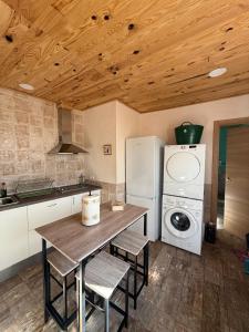 a kitchen with a table and a washing machine at An Ca La Abuela Pilar in El Real de la Jara