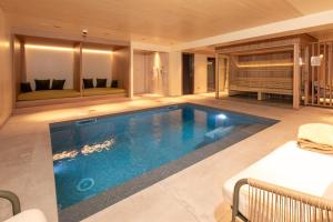 een zwembad in een hotelkamer met een bed bij Hôtel Terra Vinum in Gueberschwihr
