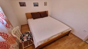a small bed in a small room with a chair at House Maja in Jadrija