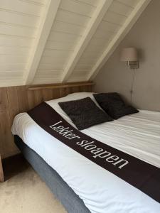 a bed with a black and white blanket on it at Herberg de Gouden Leeuw in Bronkhorst