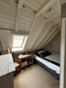 a bedroom with a bed and a desk and a window at Herberg de Gouden Leeuw in Bronkhorst