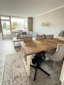 a living room with a wooden table and a couch at Hamptons Beach House Grömitz inklusive Saisonstrandkorb in Grömitz