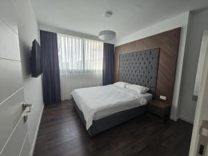 a bedroom with a bed with a large headboard at Holiday Apartments at Grand Sapphire Residence in Saint Yeorgios +22 photos
