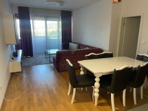 Una sala de estar con una mesa y sillas y un sofá. en Ilidza sky river, en Sarajevo