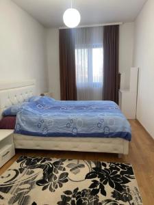 1 dormitorio con 1 cama con edredón azul y alfombra en Ilidza sky river, en Sarajevo