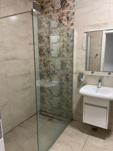 Un baño con ducha de cristal y lavabo. en Ilidza sky river, en Sarajevo 6 fotos más