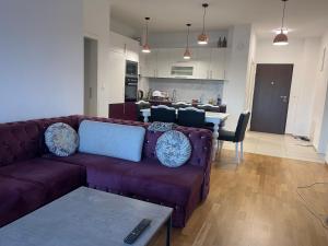 Una sala de estar con un sofá morado y una cocina. en Ilidza sky river, en Sarajevo