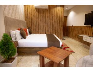a bedroom with a bed and a table in it at Hotel Eminence inn Punjab in Mohali