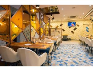 a restaurant with wooden tables and white chairs at Hotel Eminence inn Punjab in Mohali +8 photos