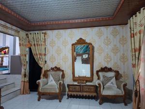 a room with two chairs and a mirror at Bahrin Homestay Lampung in Kedaton