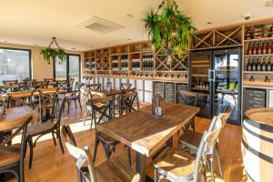 een leeg restaurant met houten tafels en stoelen bij Hôtel Terra Vinum in Gueberschwihr