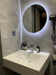 a bathroom with a white sink and a mirror at Qingwu Lane in Luoyang +12 photos