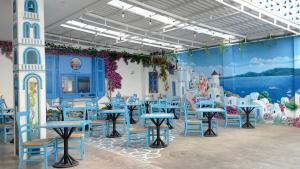 a dining room with tables and chairs and a mural at Sunset Paradise Canggu in Canggu