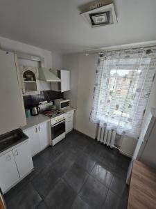 a kitchen with white cabinets and a large window at 1 кімнатна квартира в центрі міста in Sumy